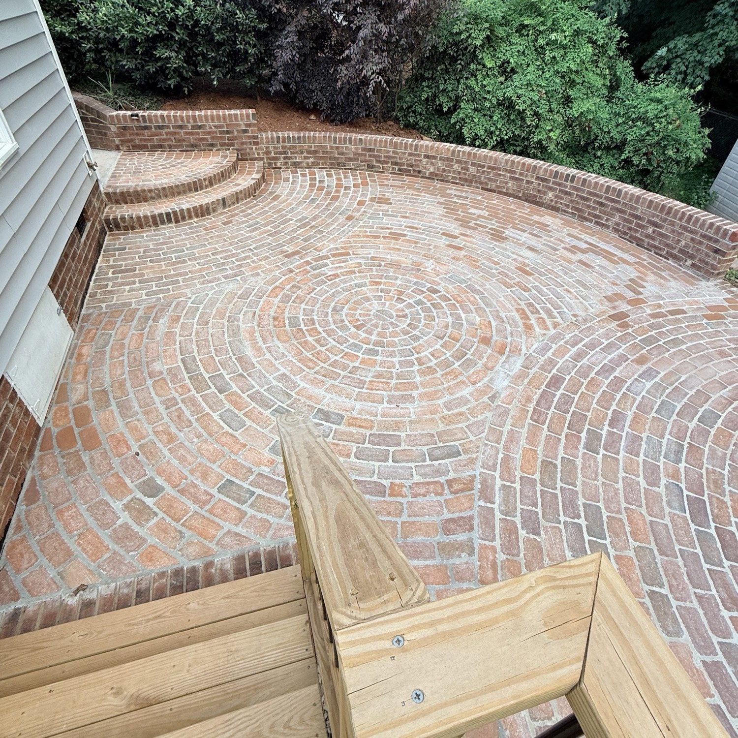 A circular brick patio with a radial pattern and a curved brick border.